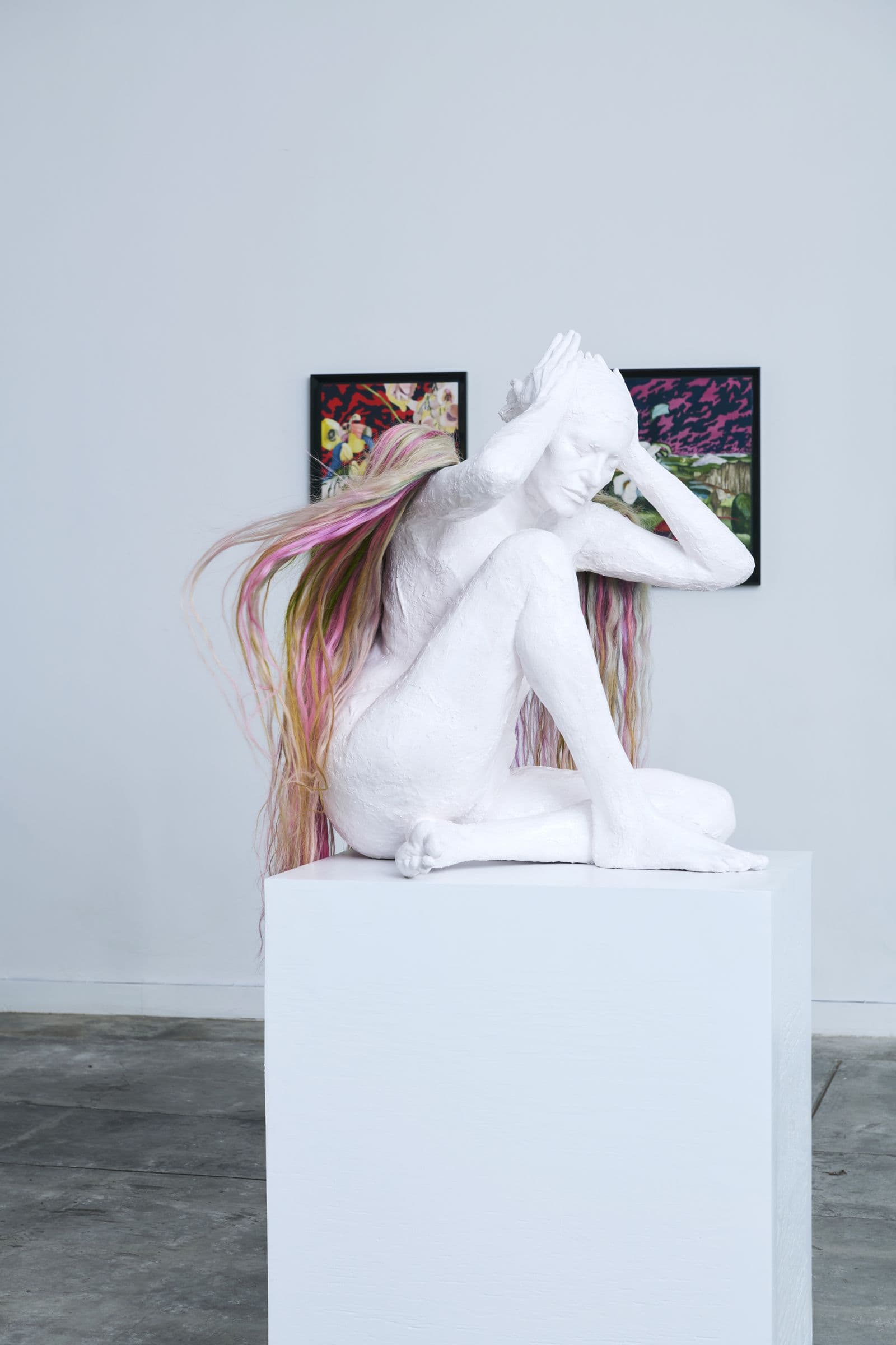 White plaster figure with flowing pink hair photographed in the gallery's natural light