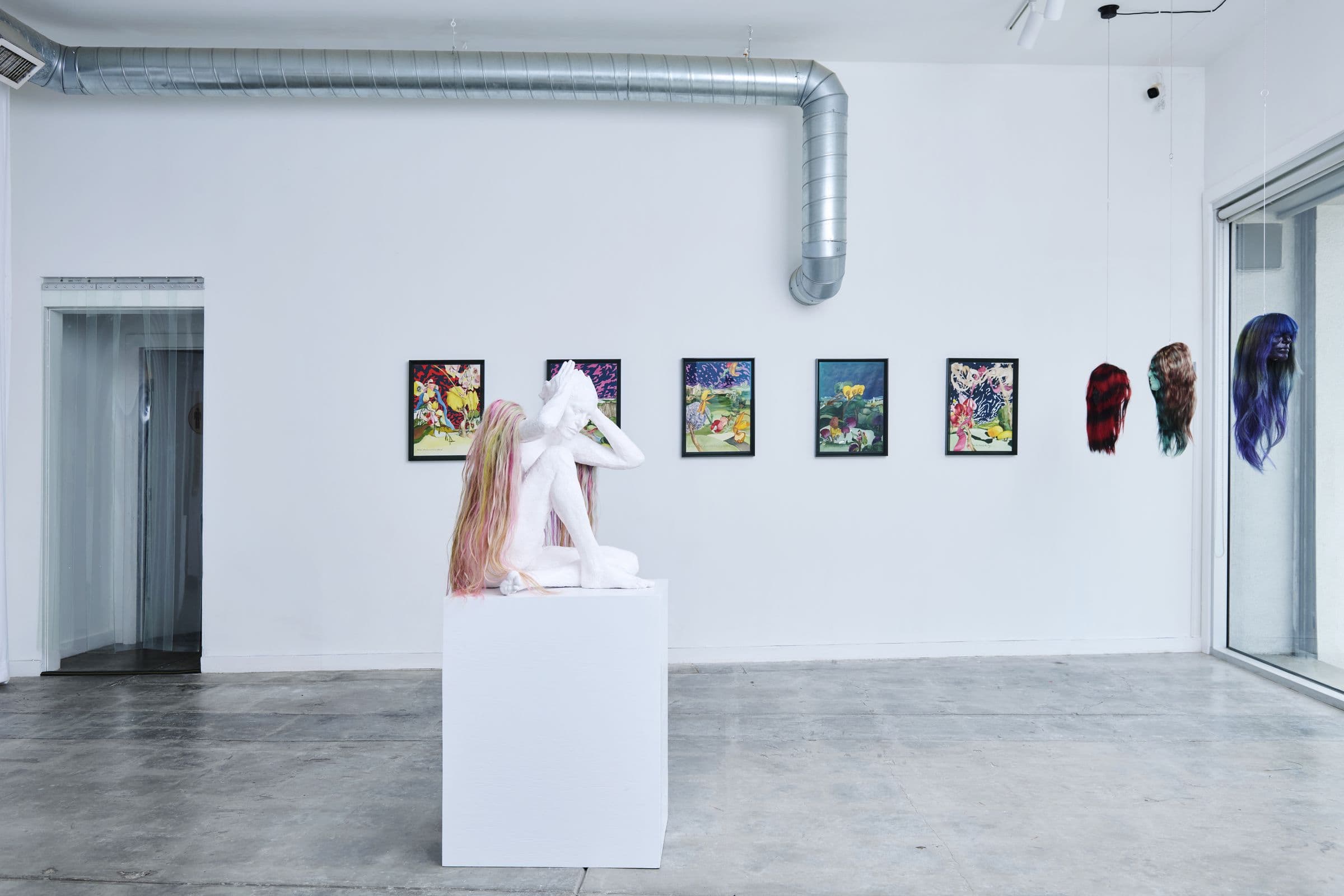 Gallery interior at Lola Gallery, Los Angeles: white walls, sheer floor-to-ceiling curtains, and polished concrete floor