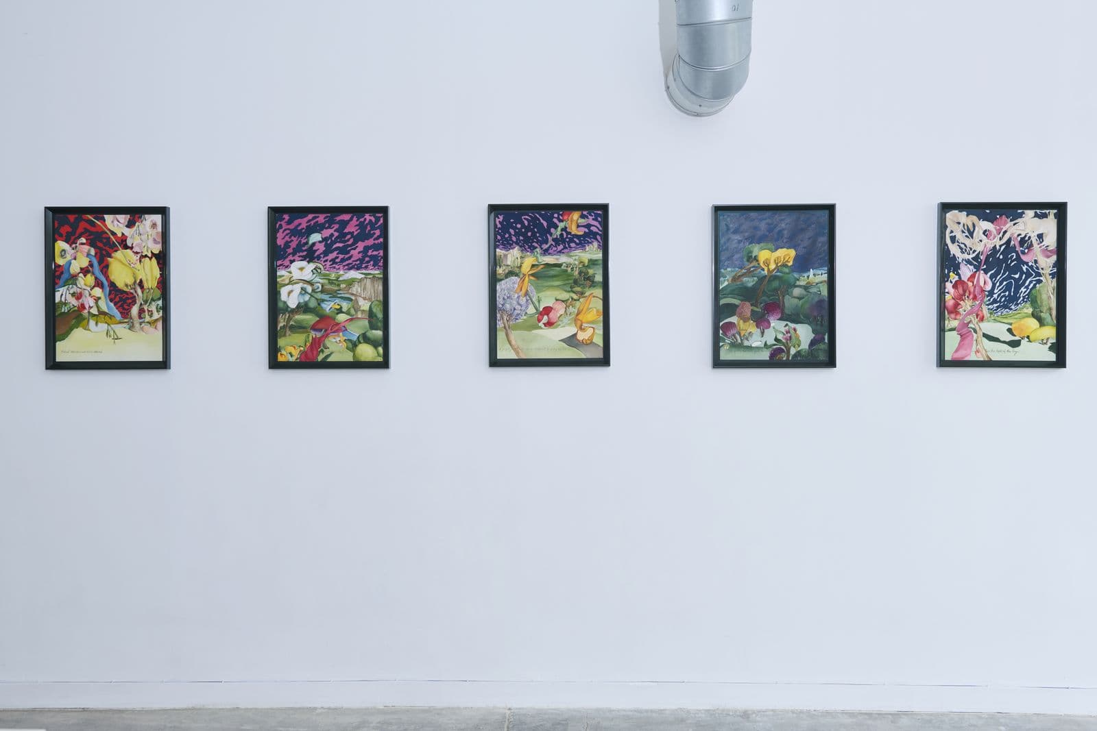 Row of framed artworks hung on a white wall at Lola Gallery